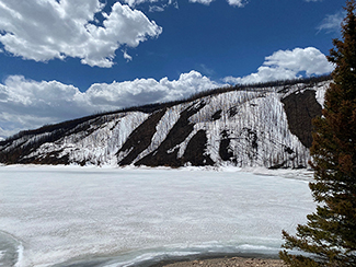 Snow covered mountain above an ice-covered reservoir