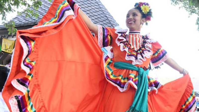 A dancer twirls her long skirt as part of a group of Mexican dancers on the plaza at Centennial Village Museum.