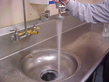 Tap water pouring into a sink